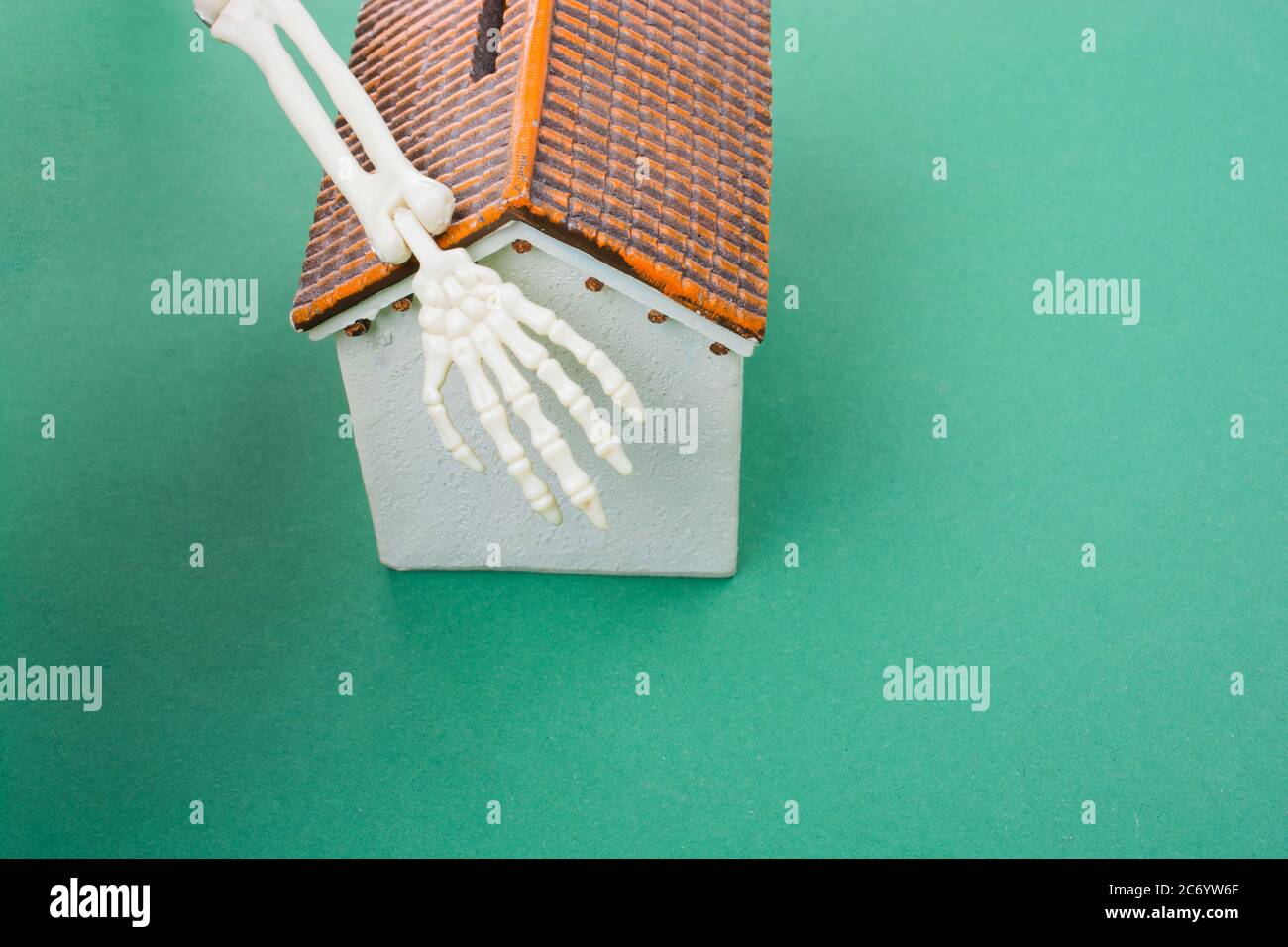 Casa modello piccolo e mano scheletro umano come concetto di orrore Foto Stock