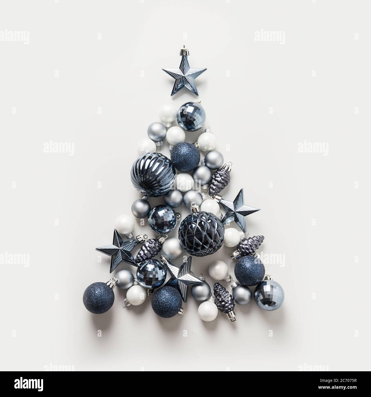 Albero di Natale fatto di stelle, palline blu su sfondo grigio. Composizione xmas. Biglietto di benvenuto per le festività. Felice anno nuovo. Foto Stock