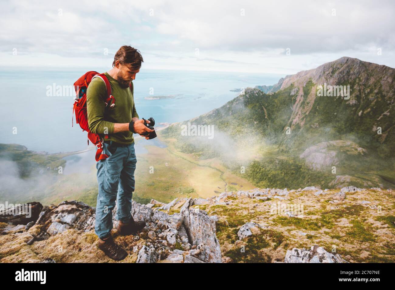 Uomo fotografo con fotocamera in montagna viaggio blogger influenzatore freelance stile di vita hobby concetto avventura estate viaggio all'aperto in Norvegia Foto Stock