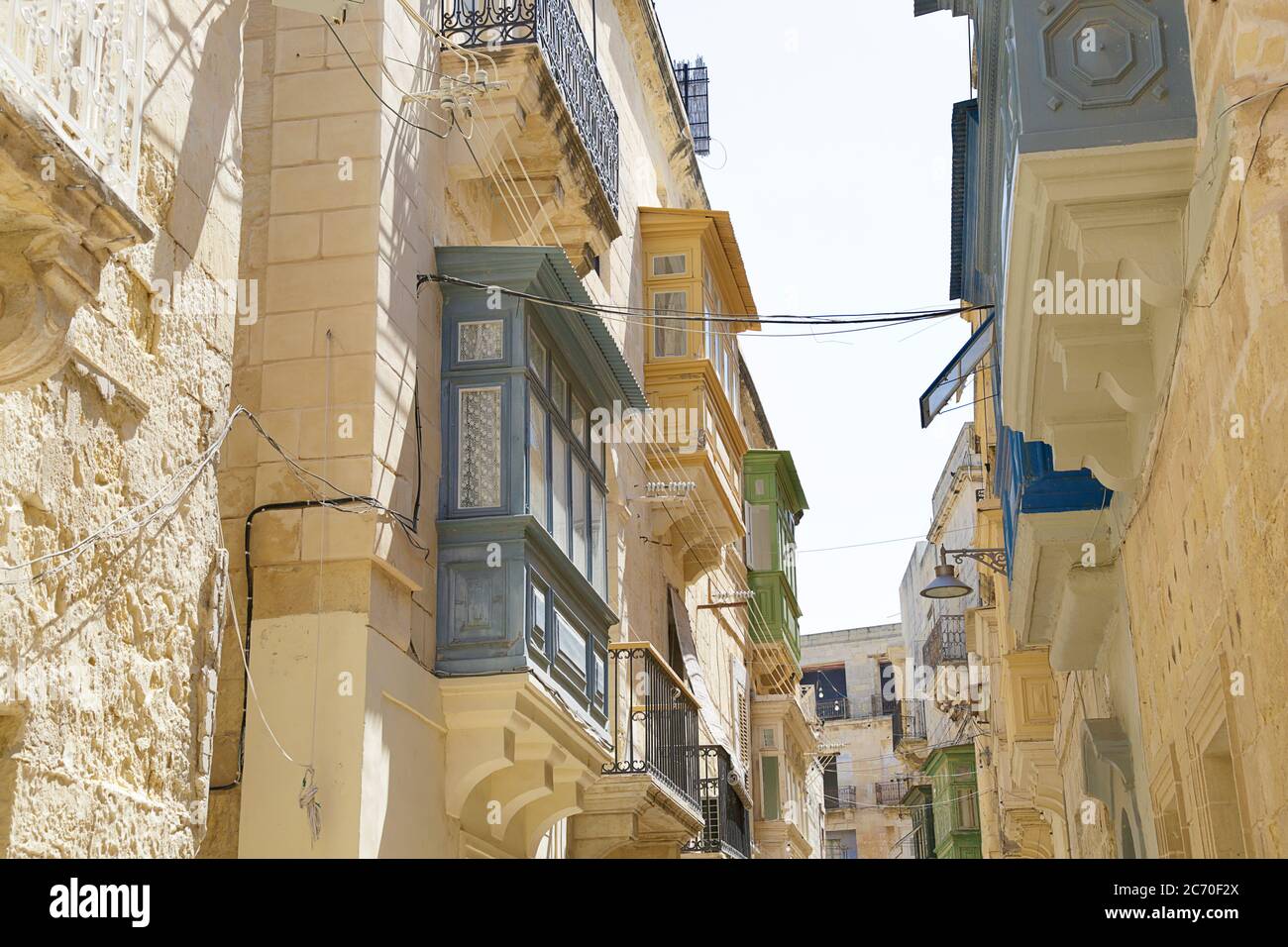Strada con edifici antichi, decorata con colorati balconi maltesi, Birgu (Vittoriosa), Malta Foto Stock