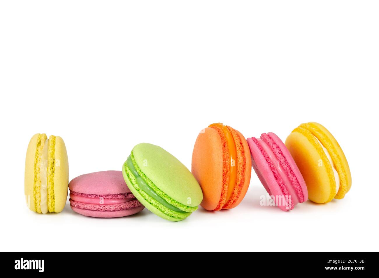 Macaroni francesi colorati in fila isolati su sfondo bianco Foto Stock