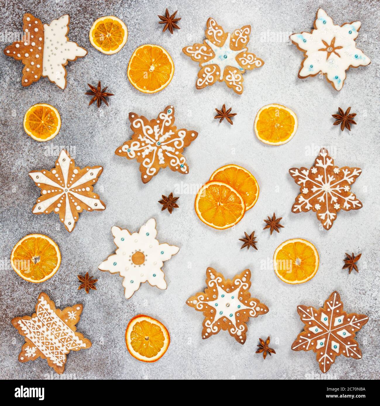 Biscotti allo zenzero di Natale nella forma fiocchi di neve, arancio secco e anice stellato su fondo di pietra grigia. Vista dall'alto. Foto Stock