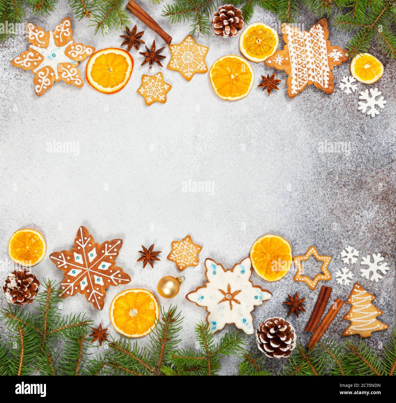 Biscotti allo zenzero natalizio in forma di fiocchi di neve, arancio secco, anice stellato e coni di abete su fondo di pietra grigia. Vista dall'alto. Simboli di Capodanno e C. Foto Stock