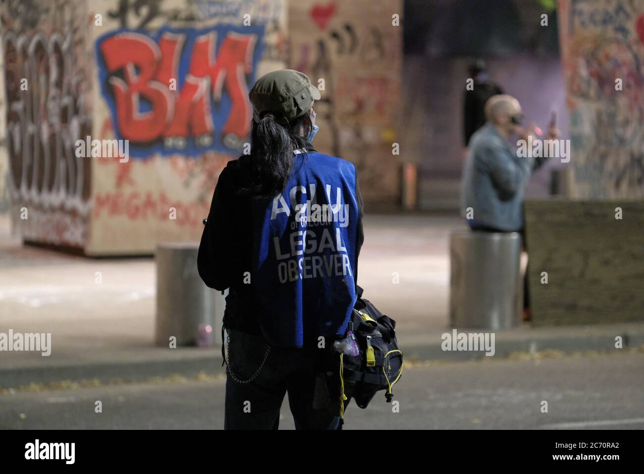 Portland, Stati Uniti. 13 luglio 2020. Un osservatore legale dell'American Civil Liberties Union (ACLU) segue la scena mentre i dimostranti si riuniscono fuori dal tribunale federale e dal Centro di giustizia di Portland, Ore., il 13 luglio 2020, per continuare a protestare contro il razzismo sistemico e la brutalità della polizia. (Foto di Alex Milan Tracy/Sipa USA) Credit: Sipa USA/Alamy Live News Foto Stock