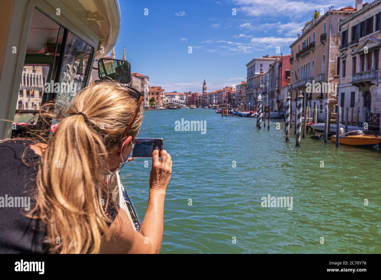 Donna con maschera facciale che scattano foto del Canal Grande a Venezia Foto Stock