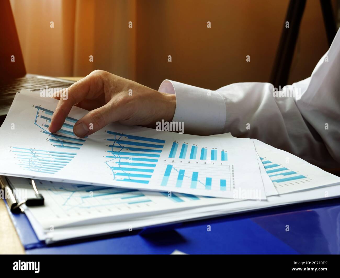 Mani tenere carte con grafici sui risultati finanziari della società. Foto Stock