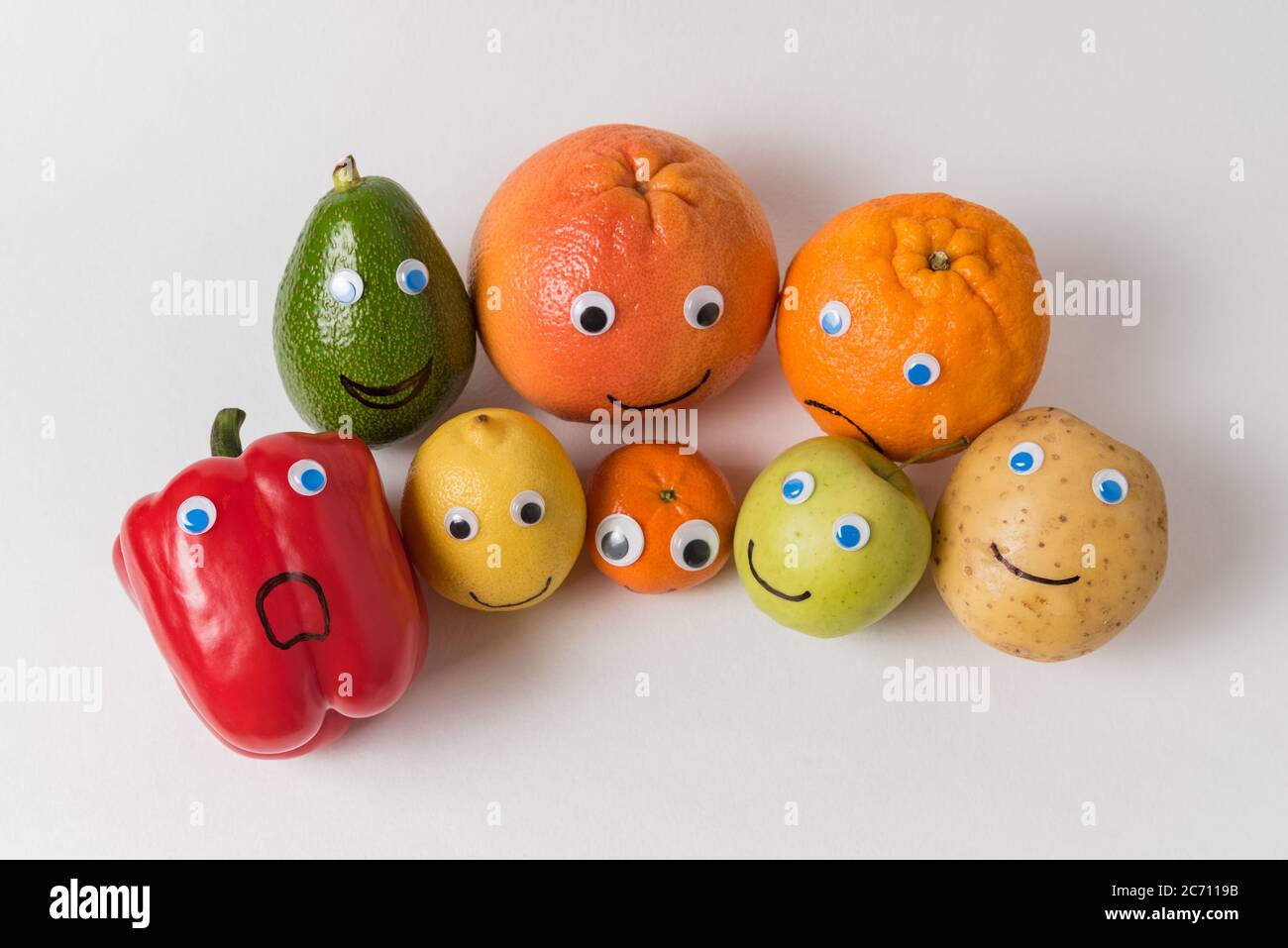 Verdure e frutta personaggi con occhi di Googly e volti divertenti. Concetto di nutrizione adeguato. Foto Stock