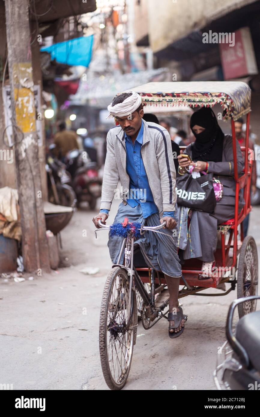 Nuova Delhi / India - 18 febbraio 2020: Risciò che porta una donna musulmana nei vicoli della Vecchia Delhi Foto Stock