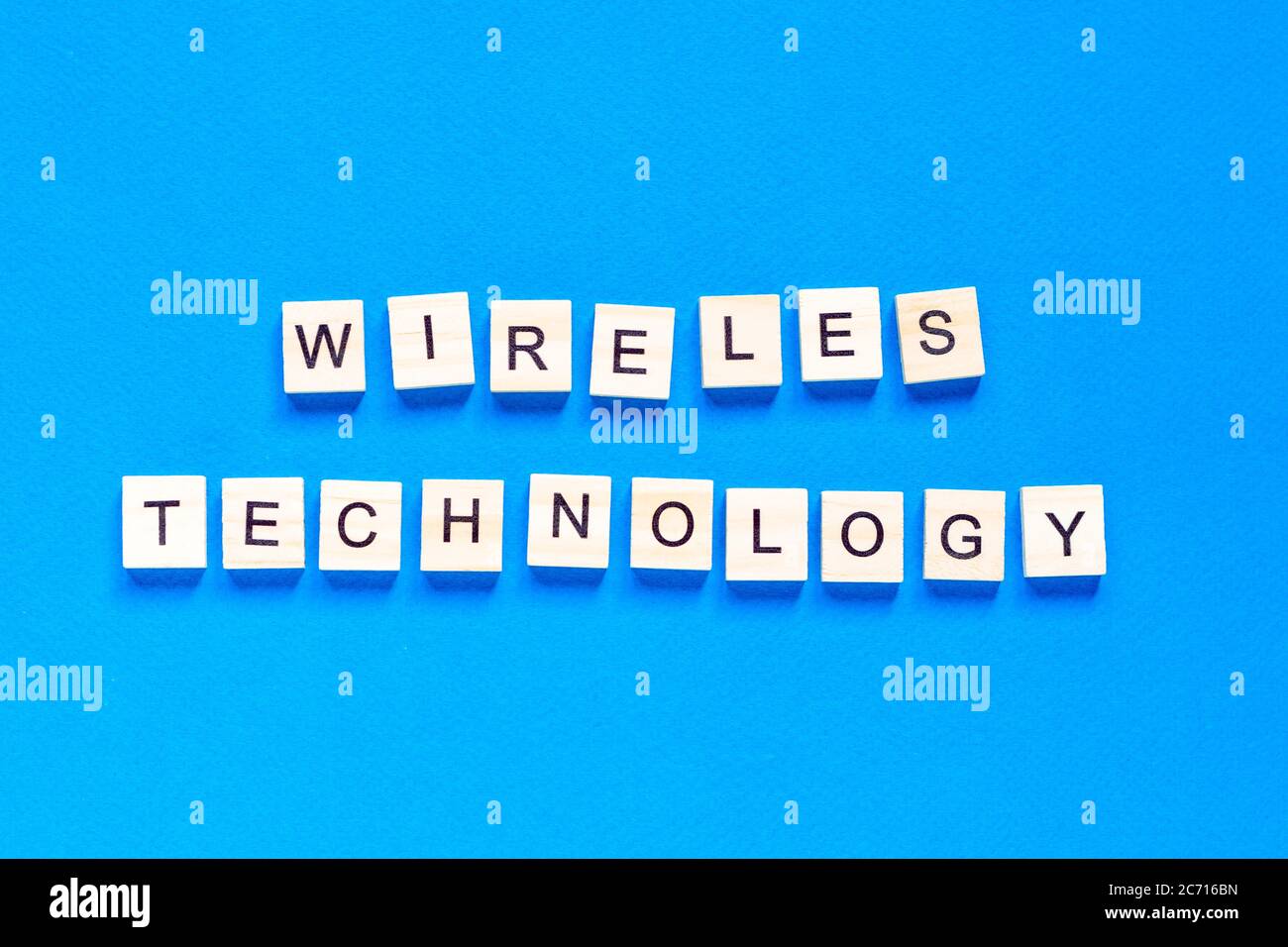 scritta in legno con tecnologia wireless. Le parole tecnologia senza fili, farro con piastrelle di legno lettera su uno sfondo bianco. Foto Stock
