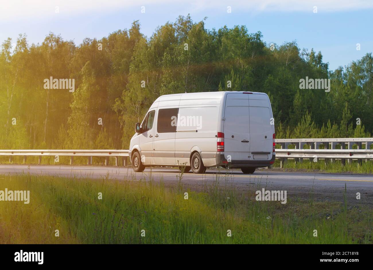 Minibus va sul paese autostrada lungo il legno Foto Stock