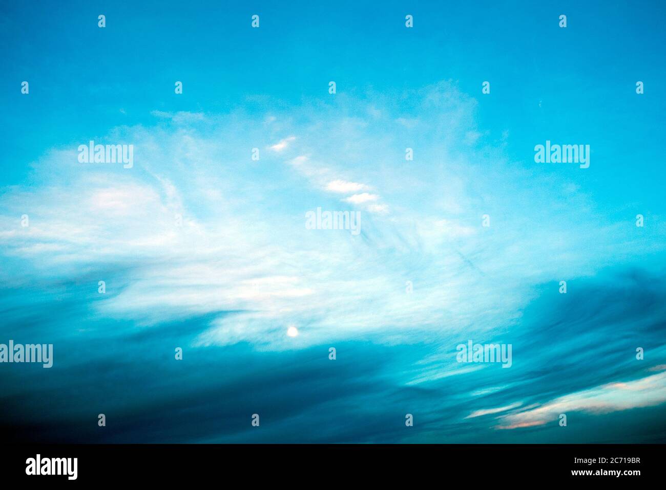 Un'immagine pittorica della Luna in un cielo blu luminoso Foto Stock