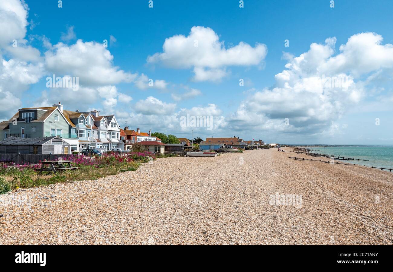 Pevensey Bay, East Sussex, Inghilterra. Tipiche case fronte spiaggia lungo la costa della spiaggia di ciottoli sulla costa meridionale dell'Inghilterra. Foto Stock