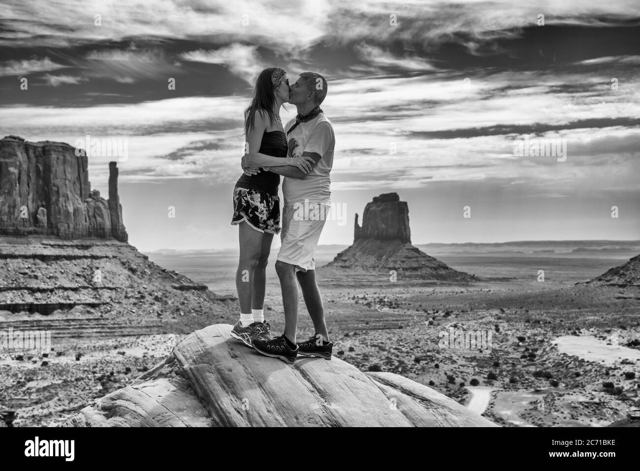 Coppia che si diverte a baciare sulla cima di una roccia visitando Monument Valley, Stati Uniti. Foto Stock