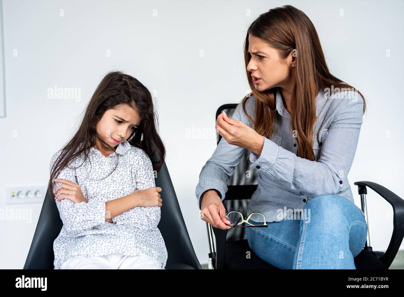 Giovane madre o sorella rigida che scolding ragazzina testarda. Foto Stock