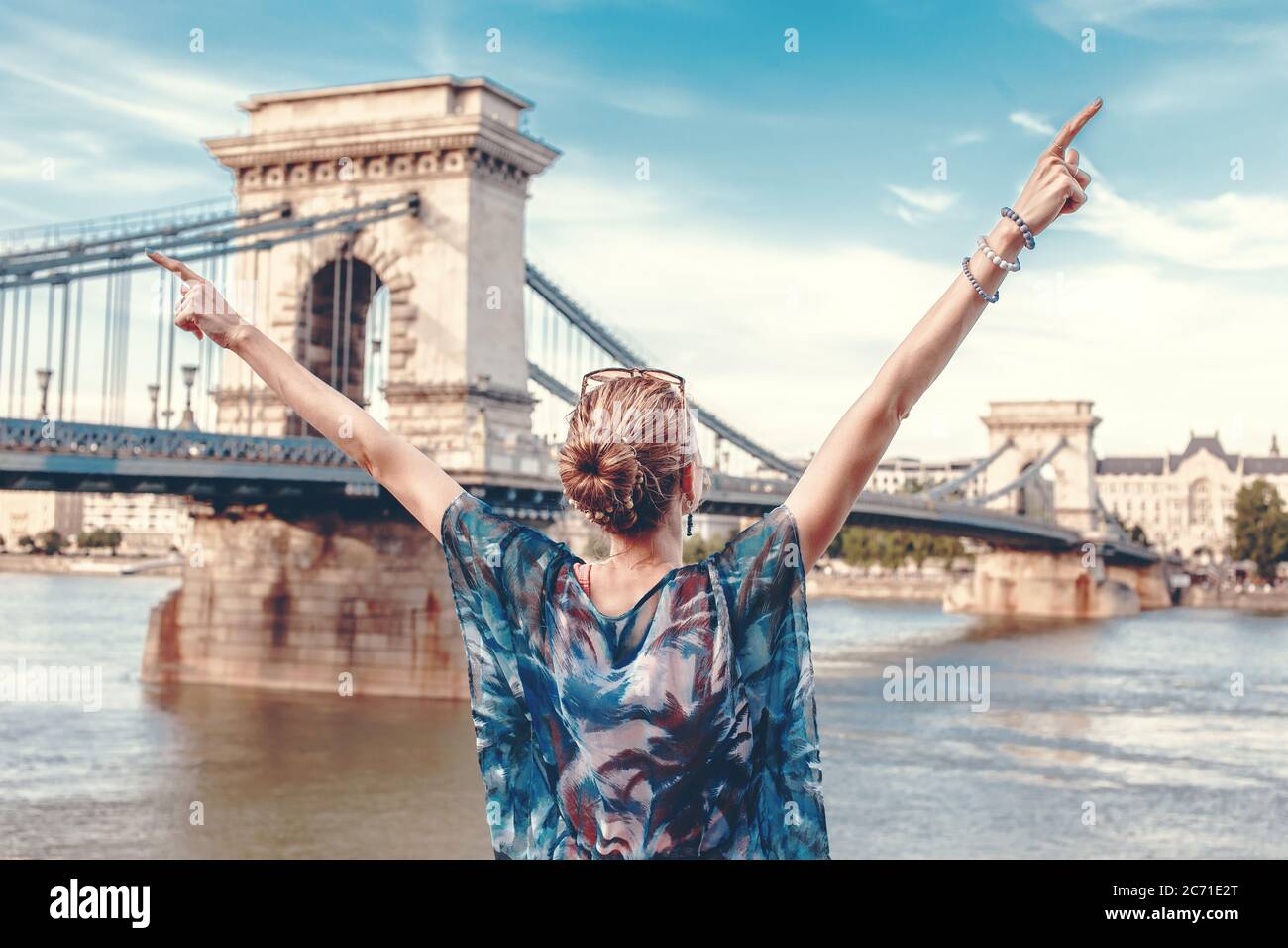 Le armi di giovane donna sollevate al panorama di Budapest con il Ponte delle catene, Lanchid, visitare l'Ungheria Foto Stock