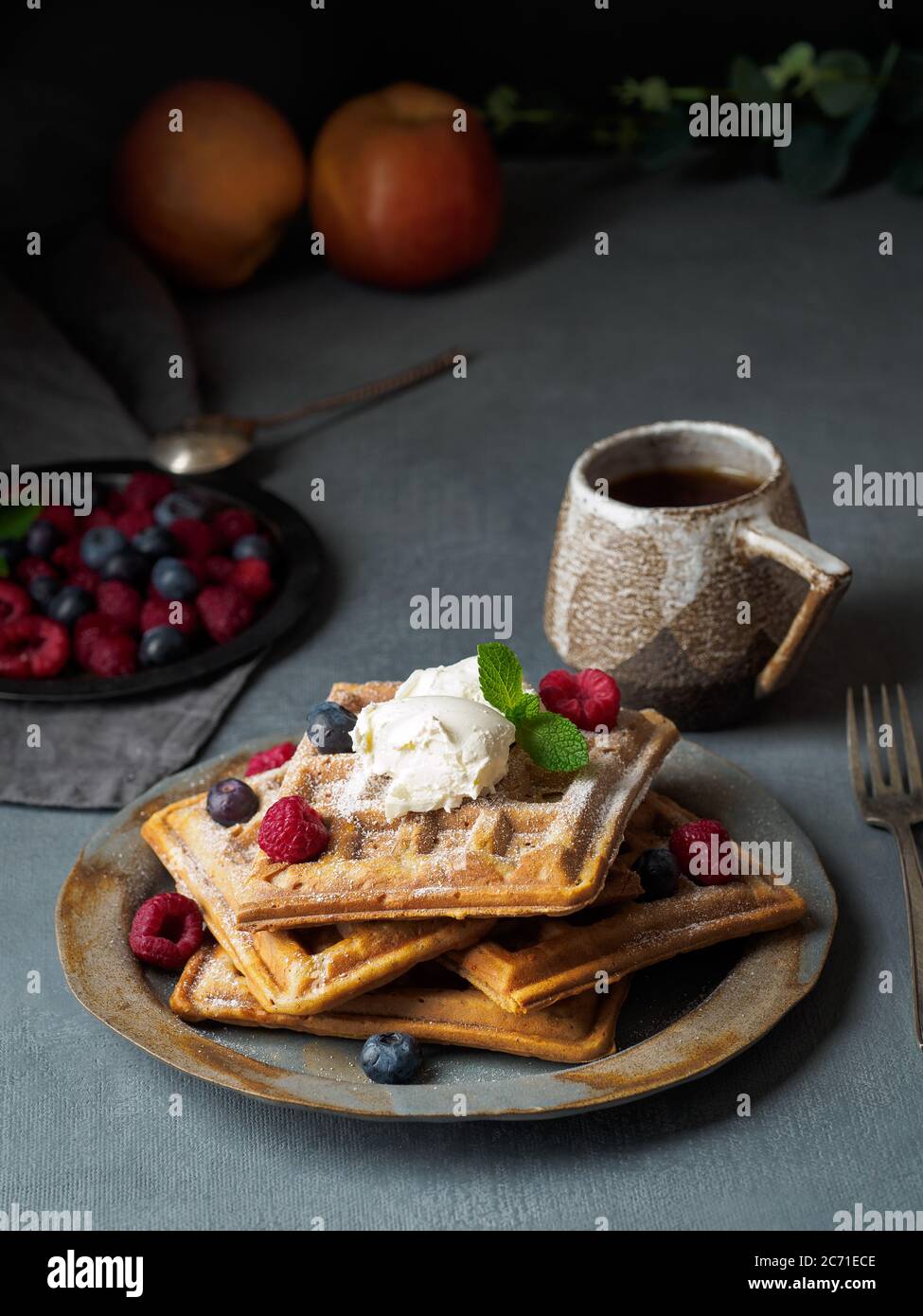 Waffle belgi con lamponi, sciroppo di cioccolato. Colazione con tè su sfondo scuro Foto Stock