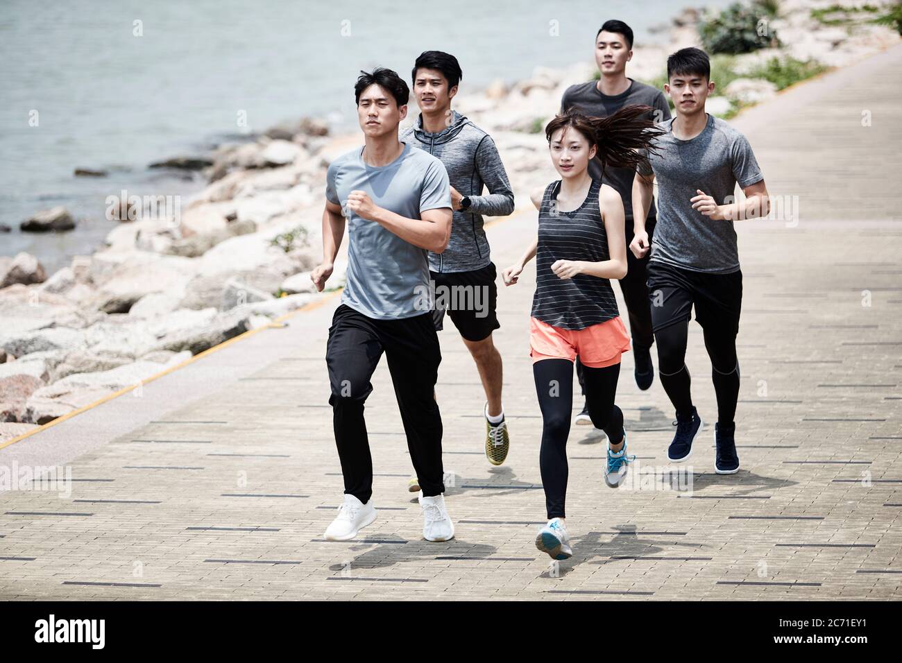 gruppo di cinque giovani adulti asiatici uomini e donne che si allenano all'aperto Foto Stock