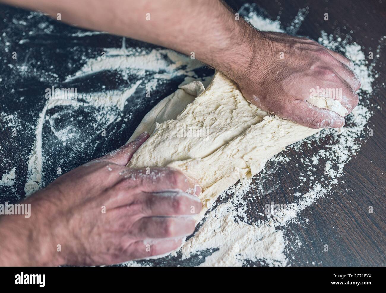 primo piano di un impasto per impastare un tavolo in legno, concetto di preparazione degli alimenti Foto Stock