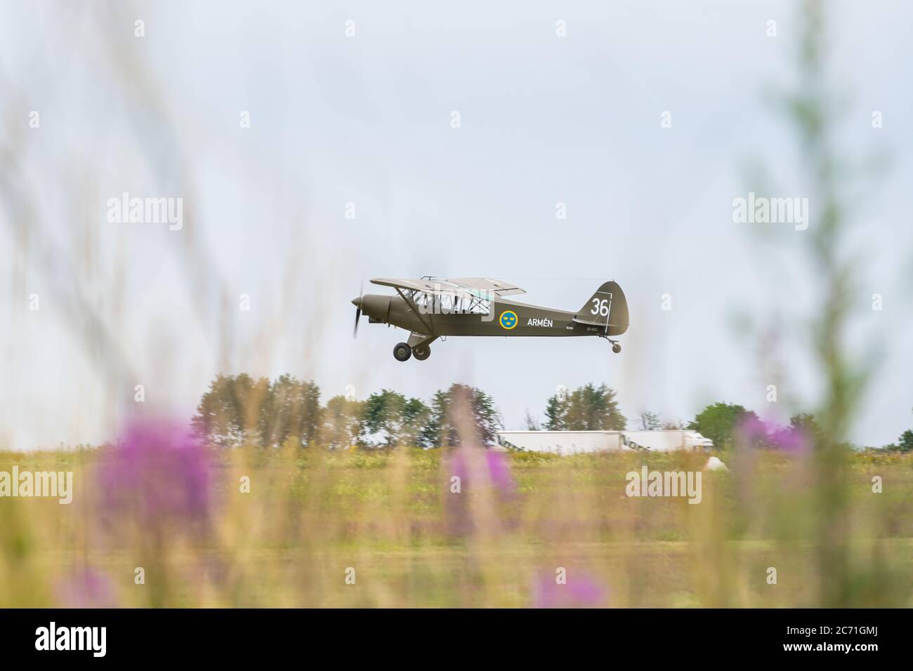 Eslov, Svezia - 10 luglio 2020: Un piccolo aereo monomotore decolli da una pista di erba. L'aereo è dipinto nei colori dell'unità dell'esercito svedese Foto Stock