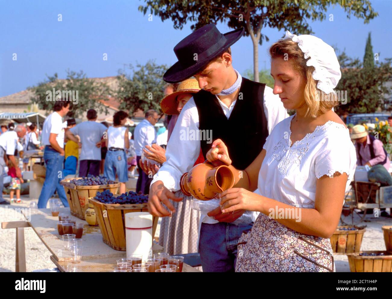 Coustelet, Francia-Settembre 29,2019:-fine della festa di raccolta del vino con ragazzo e ragazza che serve vino in costume tradizionale Foto Stock