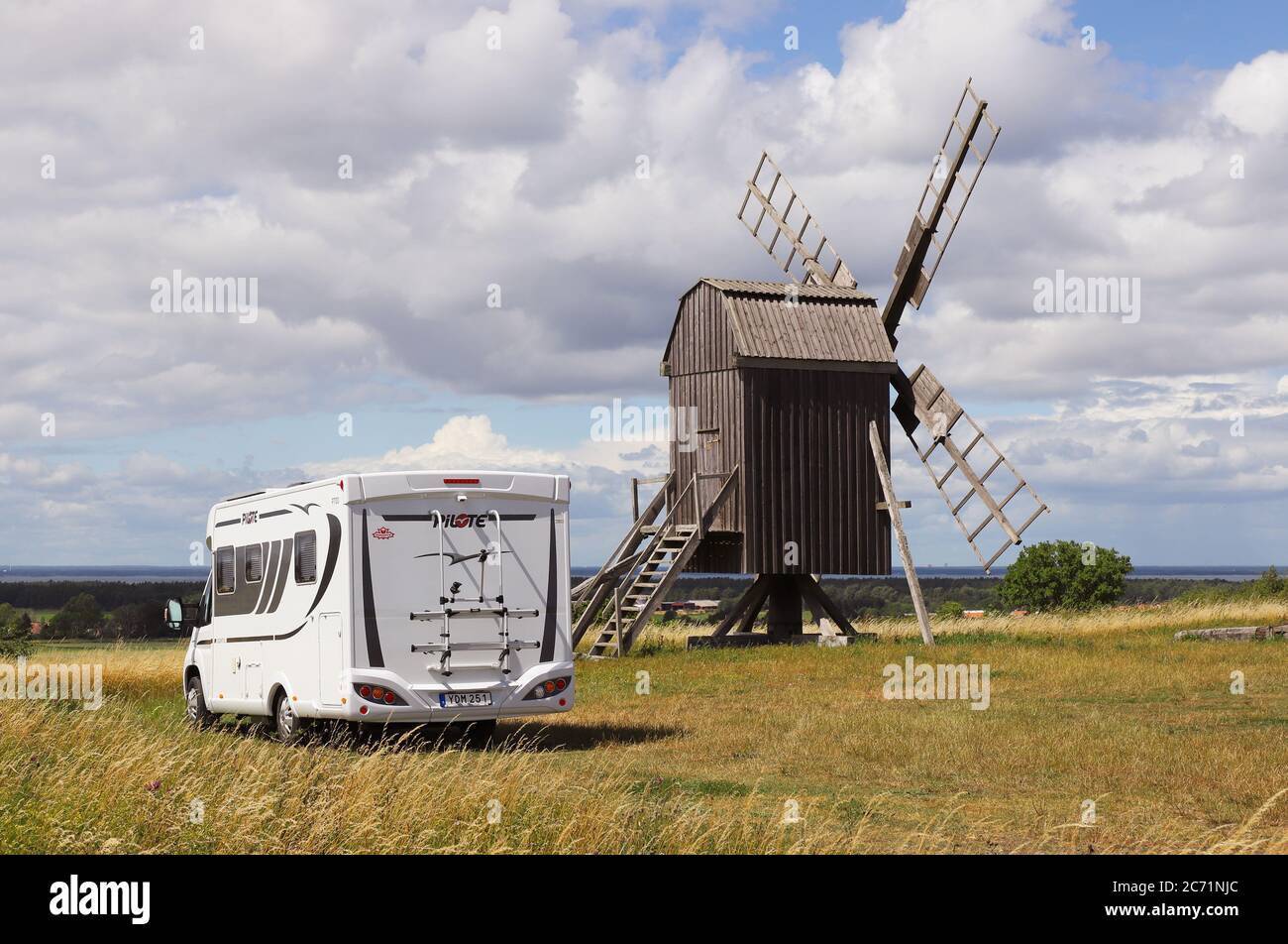 Farjestaden, Svezia - 7 luglio 2020: Camper parcheggiato vicino a un vecchio mulino a vento nella provincia svedese di Oland. Foto Stock