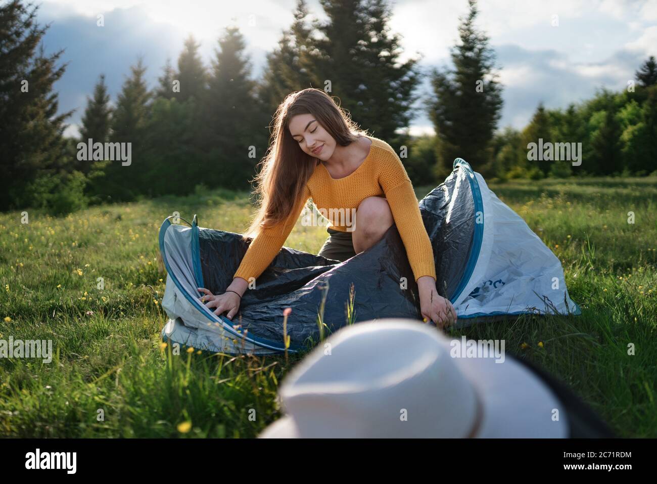 Felice giovane donna che usa tenda rifugio all'aperto in estate natura. Foto Stock