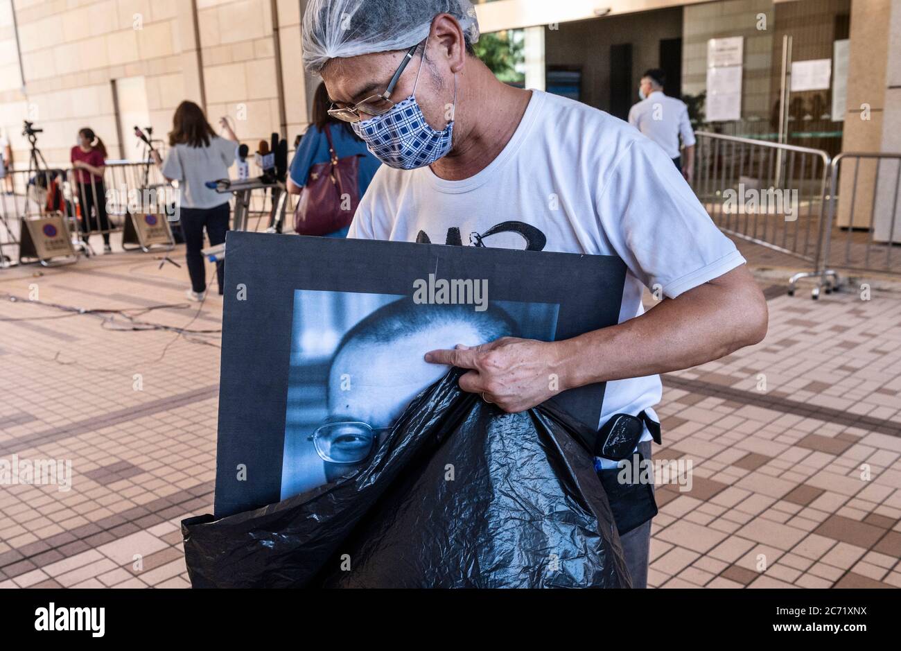 Hong Kong, Cina. 13 luglio 2020. Un attivista mette via un ritratto del dissidente cinese e del vincitore del Premio Nobel per la pace Liu Xiaobo dopo aver partecipato a una menzione alla Corte dei Magistrati di Kowloon Ovest.13 attivisti che hanno guidato la veglia a lume di candela di Piazza Tiananmen del 2020 ´s il 4 giugno sono comparsi in tribunale e sono stati accusati di tenere un non autorizzato raccolta. Credit: SOPA Images Limited/Alamy Live News Foto Stock