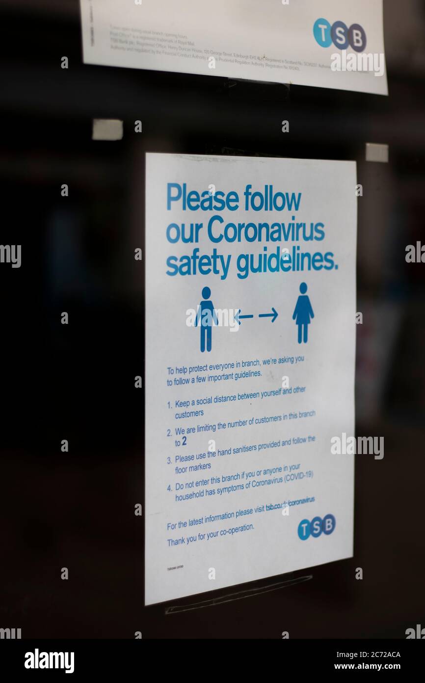 COVID 19 direttive sulla sicurezza pandemica firmano sulla porta della filiale locale di TSB Trustees Saving Bank Foto Stock