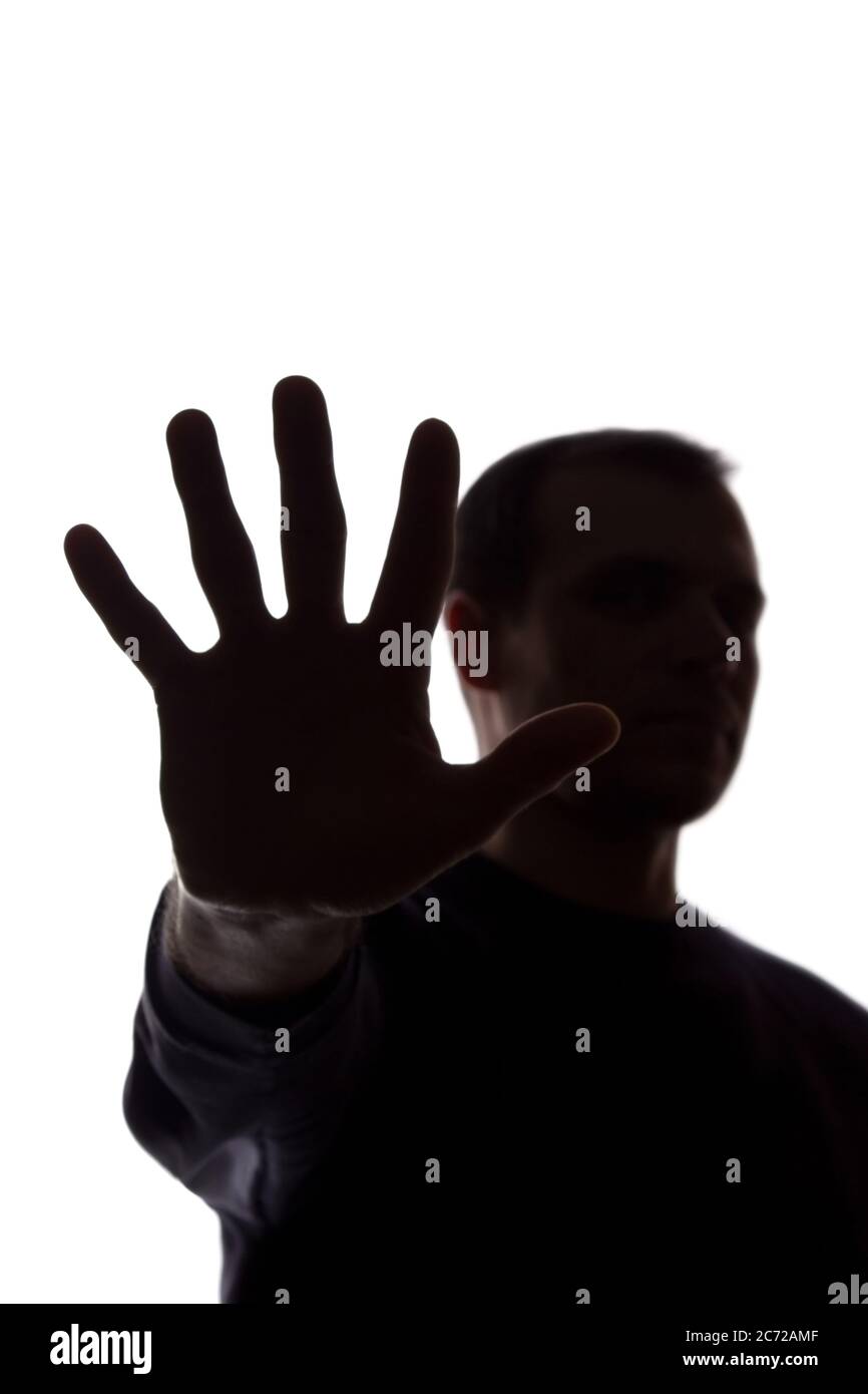 La mano di un giovane uomo copre il suo volto, protesta - silhouette, concetto senza commento Foto Stock