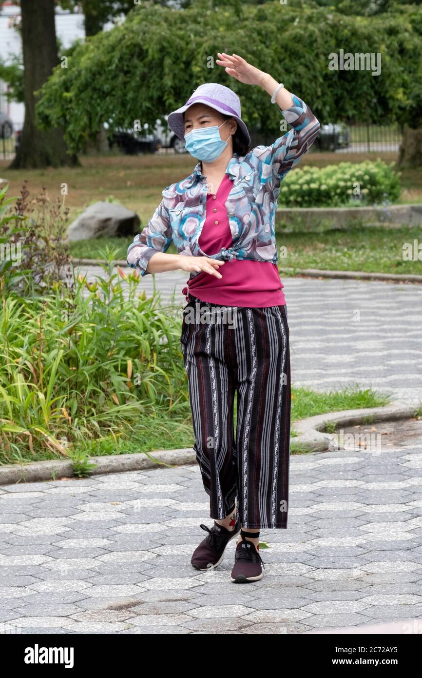 Una donna asiatica americana di mezza età pratica la danza cinese moderna. A Kissena Park, Flushing, New York City. Foto Stock