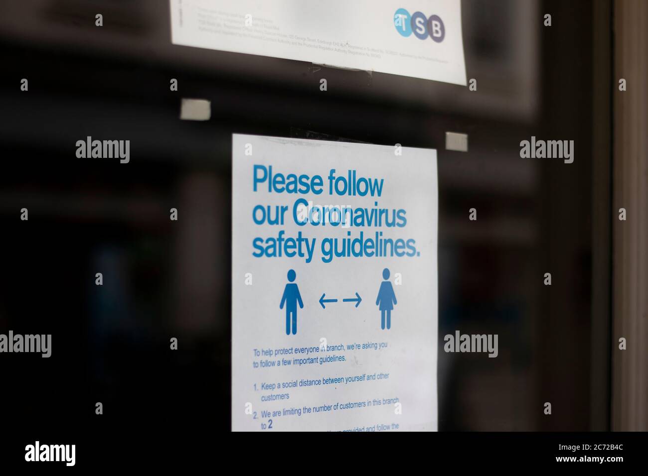 COVID 19 direttive sulla sicurezza pandemica firmano sulla porta della filiale locale di TSB Trustees Saving Bank Foto Stock