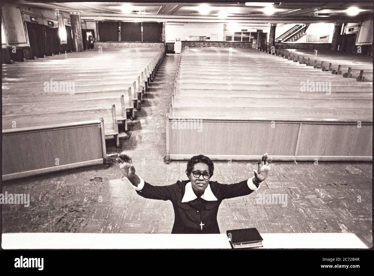 Suor Ollie Smith, una devota donna cristiana si inginocchia in preghiera vicino all'altare in una chiesa vuota a Brooklyn, New York nel 1981. Foto Stock