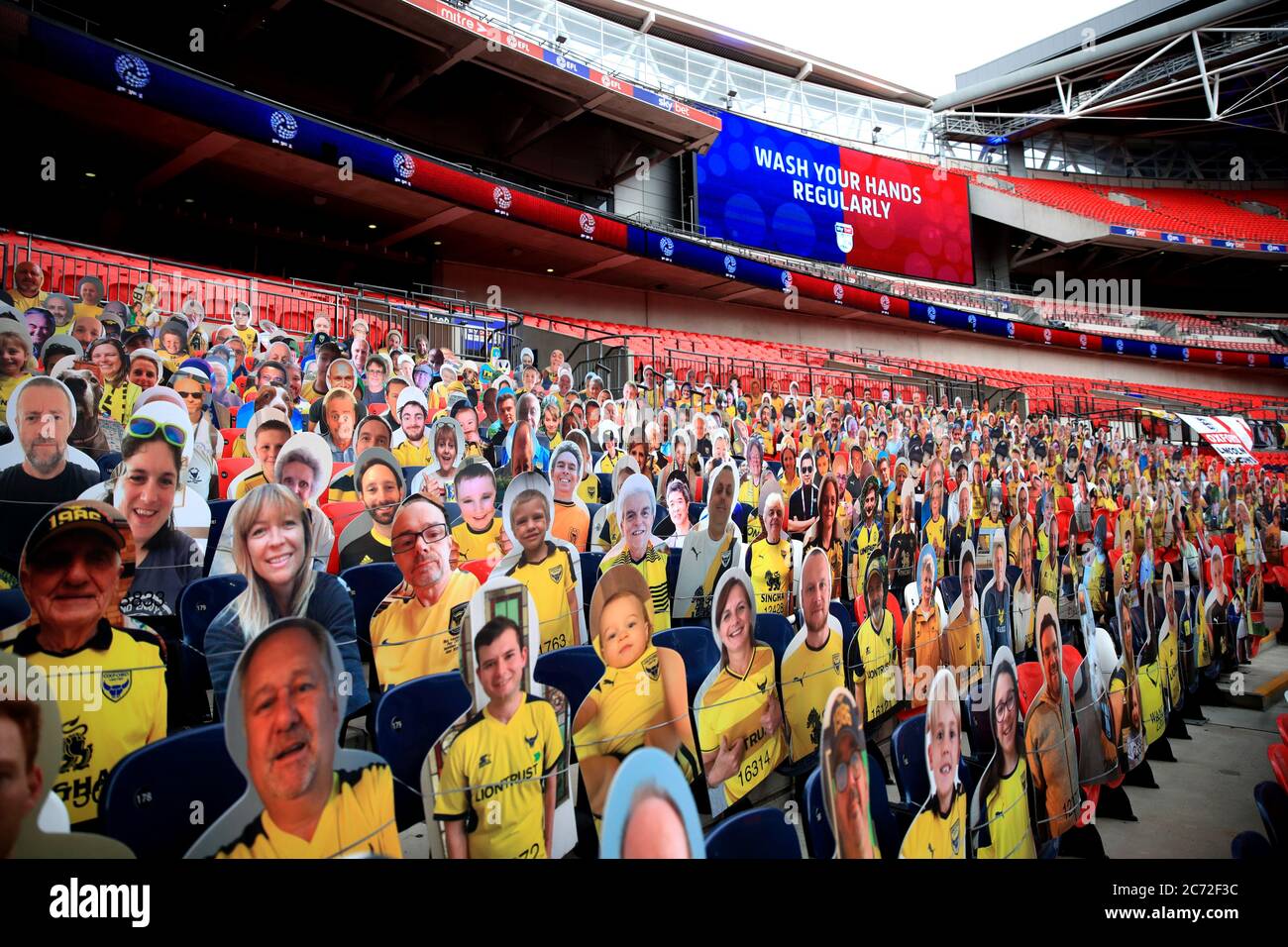 Una visione generale del taglio di cartone dei tifosi negli stand con messaggi su come prevenire la diffusione del coronavirus sul grande schermo prima della finale di gioco di Sky Bet League One al Wembley Stadium, Londra. Foto Stock