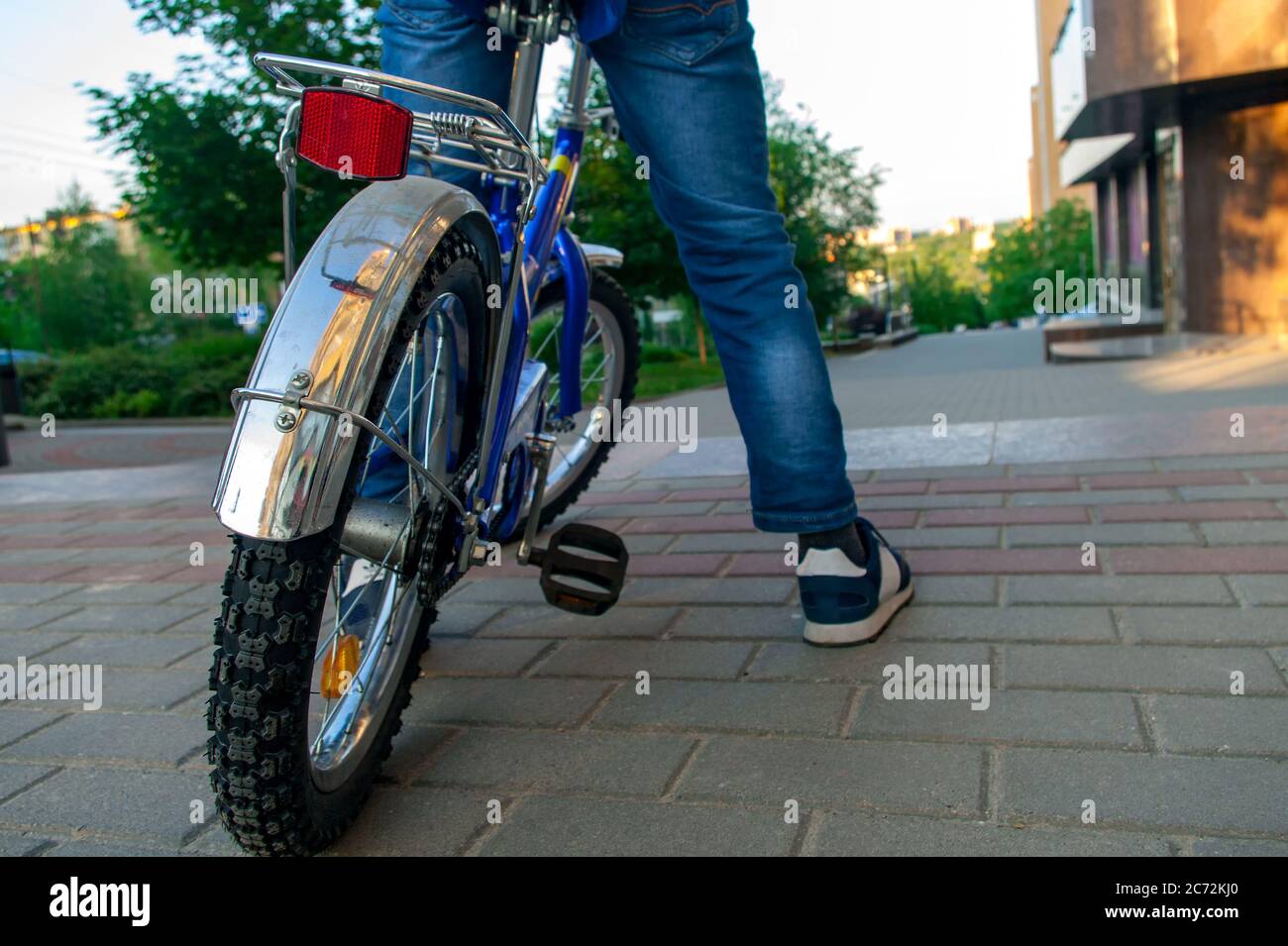 Il ragazzo è pronto a fare un giro in bicicletta per la strada della città Foto Stock