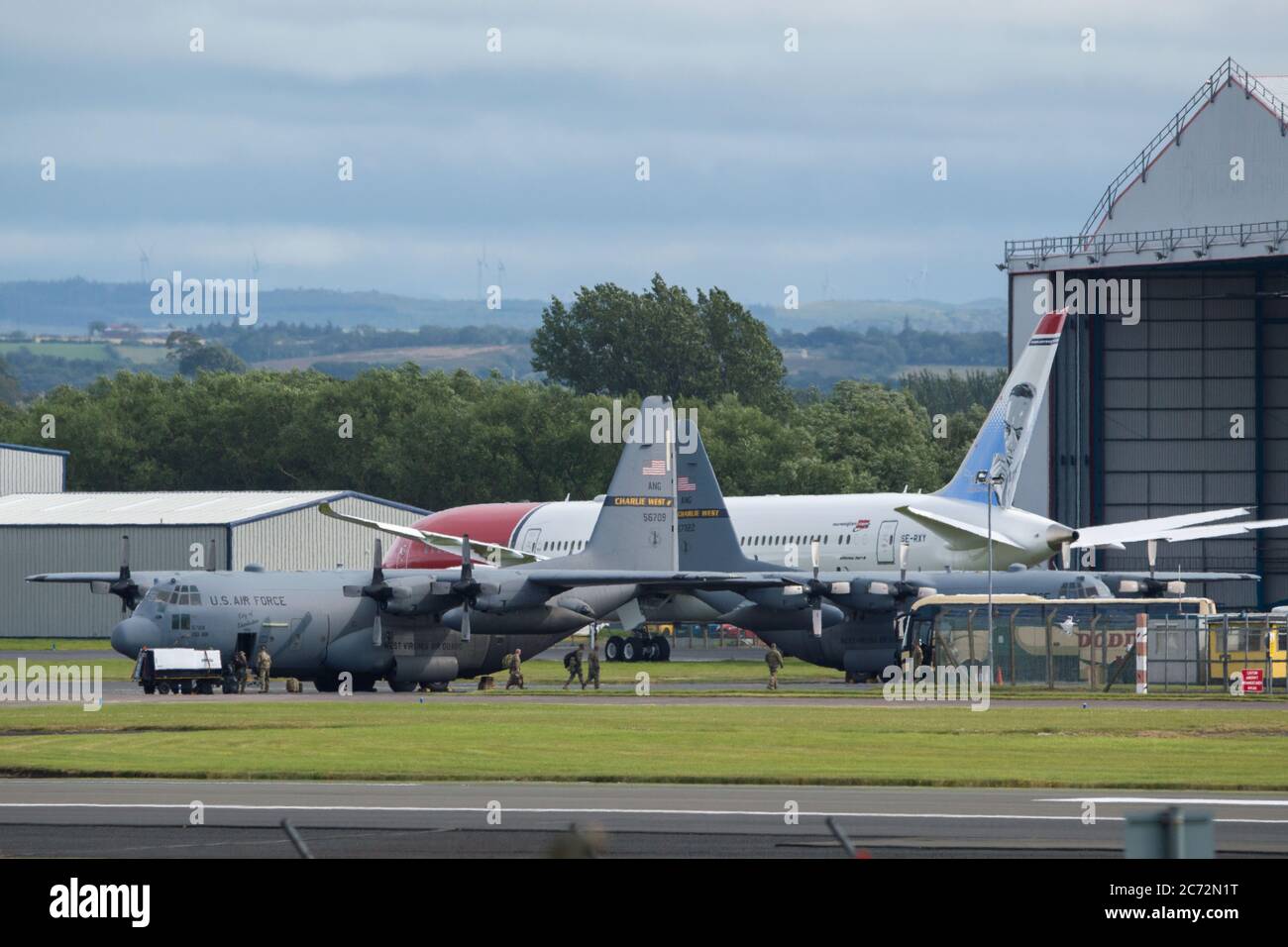 Prestwick, Scozia, Regno Unito. 13 luglio 2020. Nella foto: (A sinistra) un aereo canadese dell'aeronautica C130 Hercules (reg 130616) visto in partenza dall'aeroporto di Prestwick. Era atterrato un'ora prima e sembra che questa fosse una sosta per il rifornimento dell'equipaggio; (a destra) UN aereo dell'aviazione C130 Hercules degli Stati Uniti (Reg 56709) siede sul asfalto dal Ryanair Hanger. Credit: Colin Fisher/Alamy Live News Foto Stock
