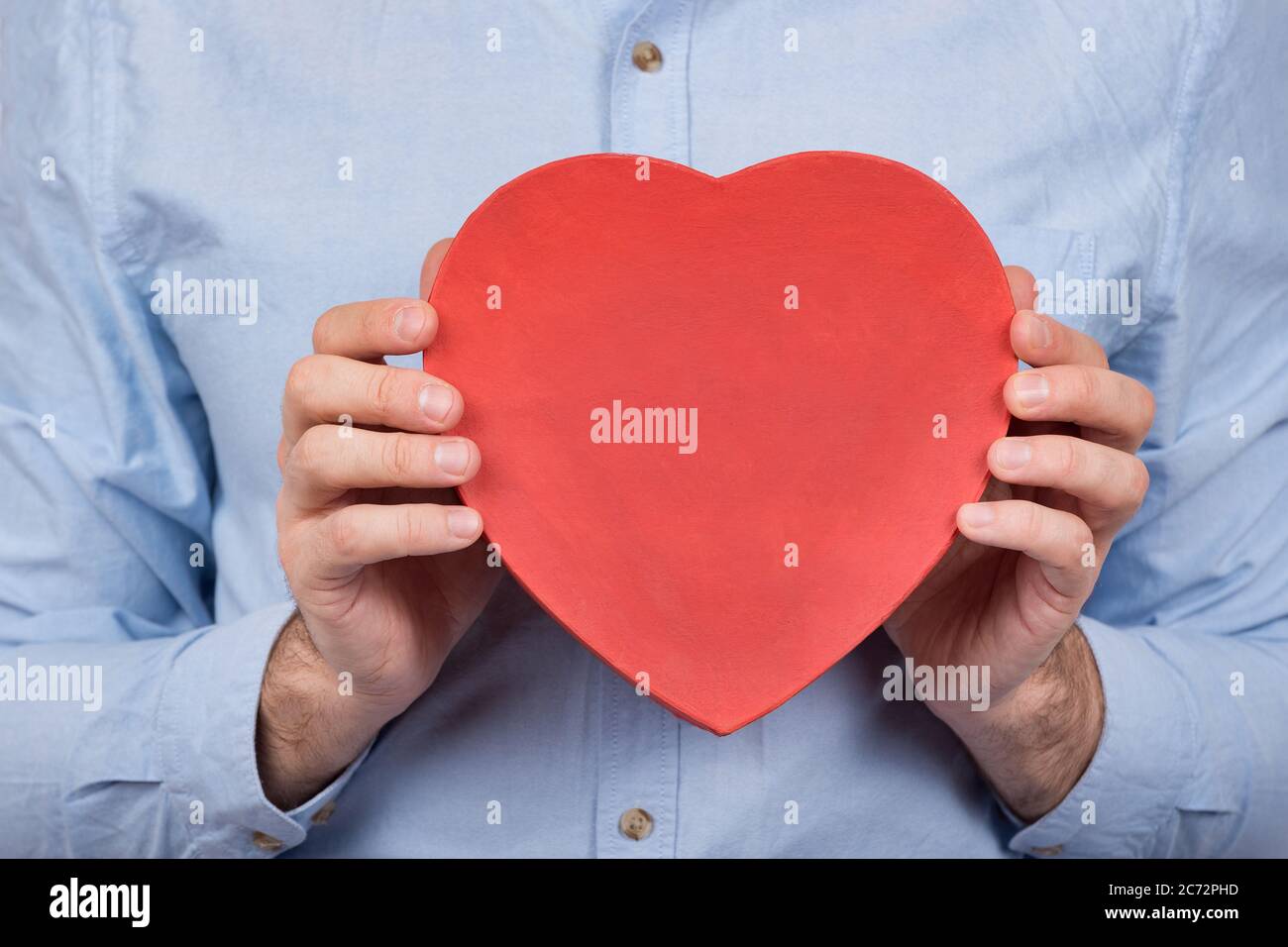 Grande scatola rossa a forma di cuore nelle mani maschili. Regalo per  amato. Regalo per San Valentino Foto stock - Alamy