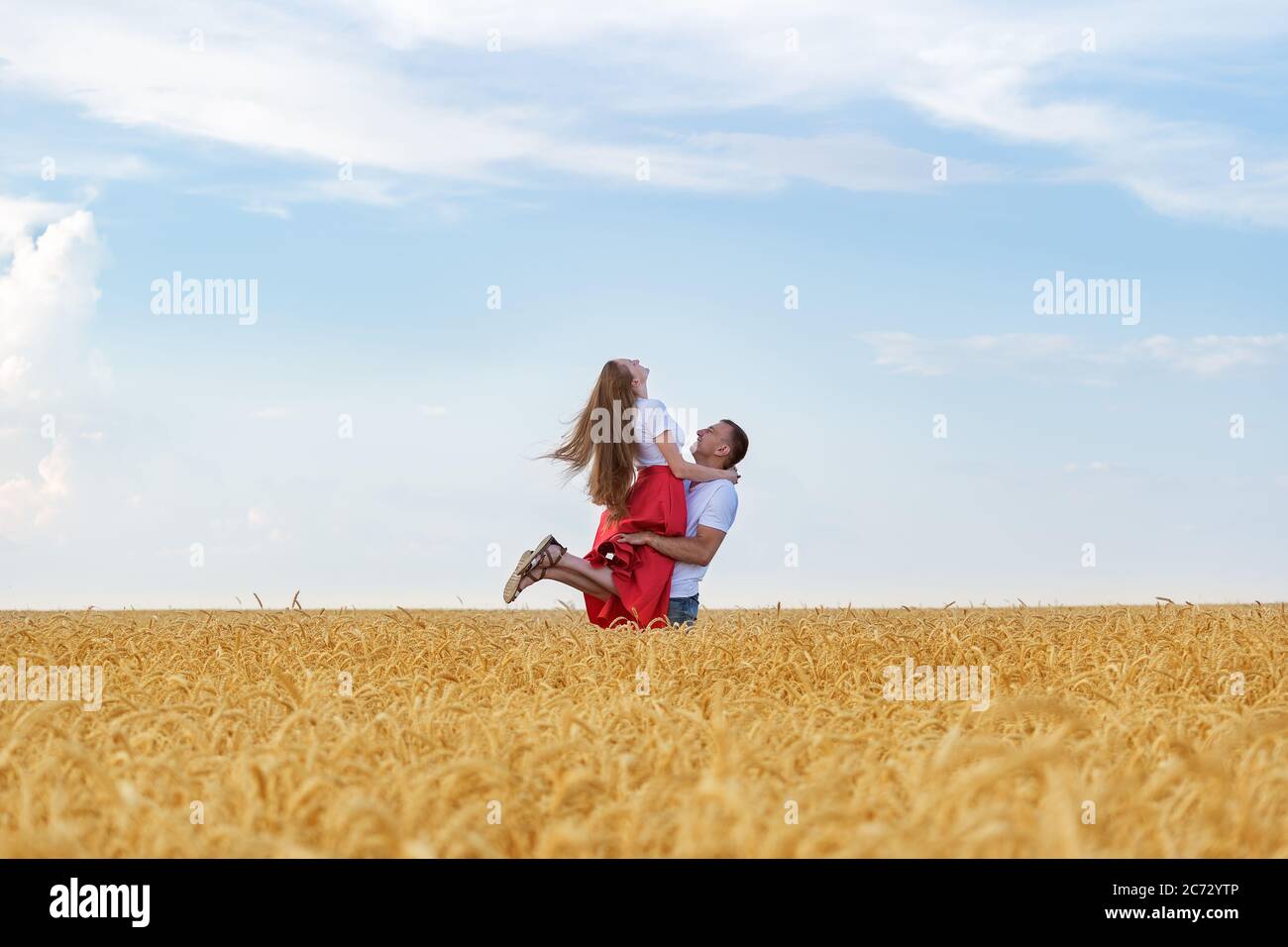 Felice giovane coppia che si aggira in campo. L'uomo tiene la donna. Foto Stock