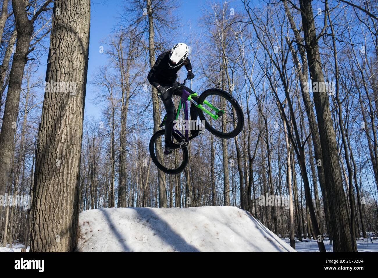 il pilota mtb fa trick sul salto di sporcizia in inverno. Ciclista che fa acrobazie di trampolino Foto Stock