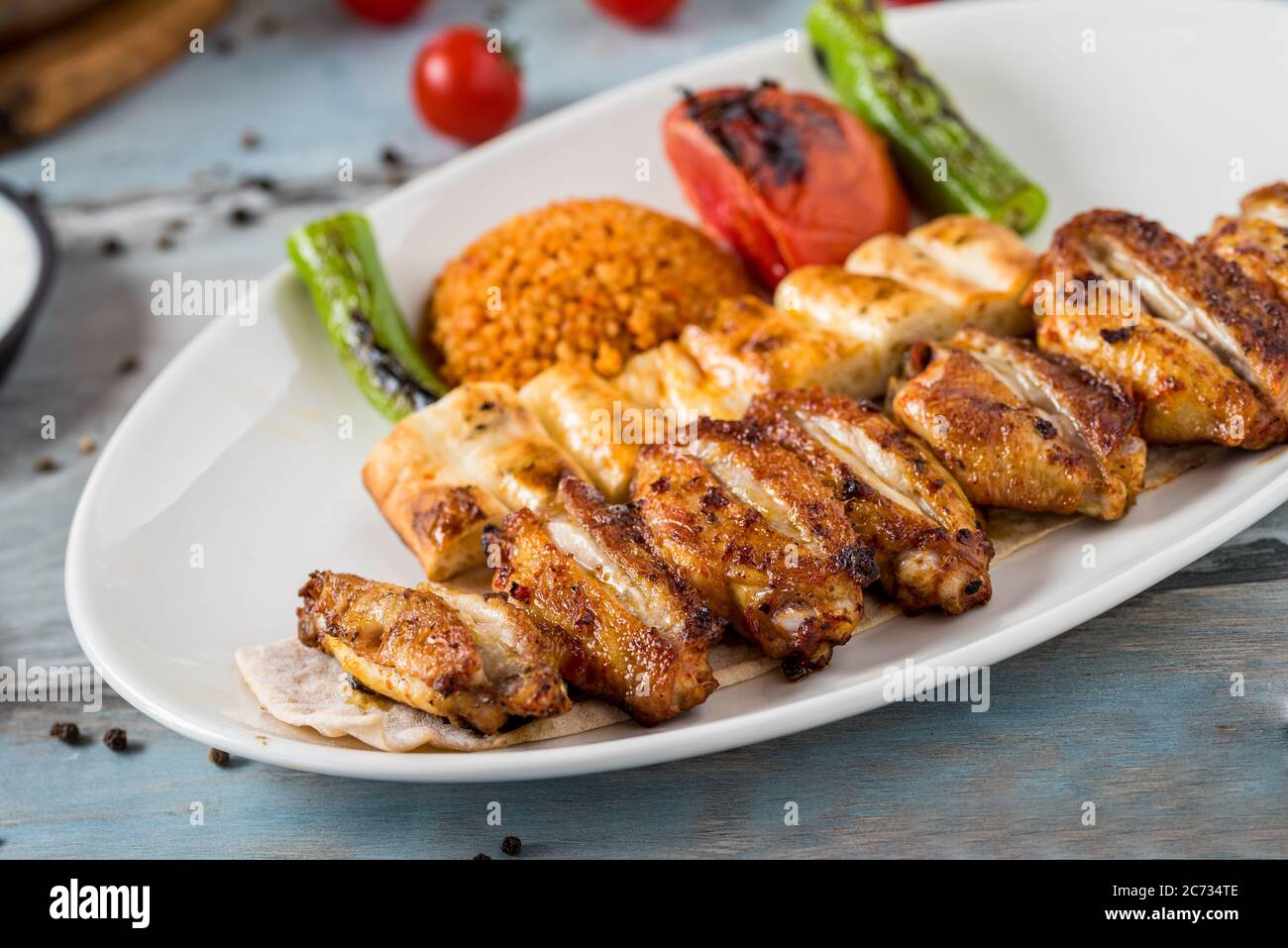 Cucina turca, ali di pollo alla griglia. Ali di pollo grigliate su sfondo di legno Foto Stock