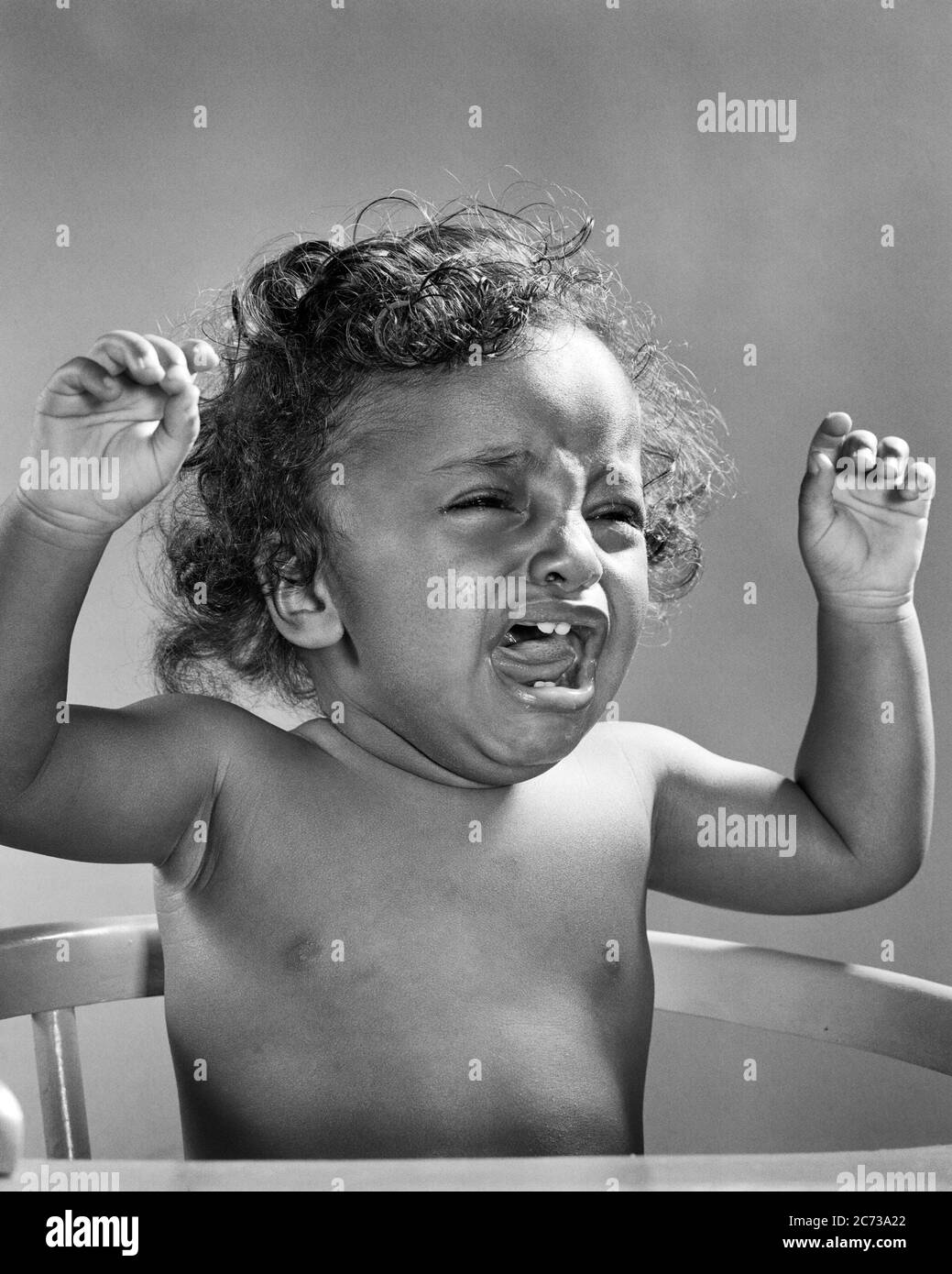 1940 ANNI 1950 ESTREMAMENTE INFELICE PIANGARE AFROAMERICANO BABY ARMI SOLLEVATE IN PROTESTA SEDUTA IN ALTA SEDIA MOLTO SCONVOLTO - N326 HAR001 HARS MEZZA LUNGHEZZA B&W TRISTEZZA MOLTO TESTA E SPALLE FORZA AFROAMERICANI AFROAMERICANI COMPOSITO ECCITAZIONE FORTE FORTE FORTE E POTENTE ETNIA NERA IN ESTREMAMENTE PROTESTANTE GIOVANI NERO E BIANCO HAR001 VECCHIO STILE AFRICANO AMERICANI Foto Stock