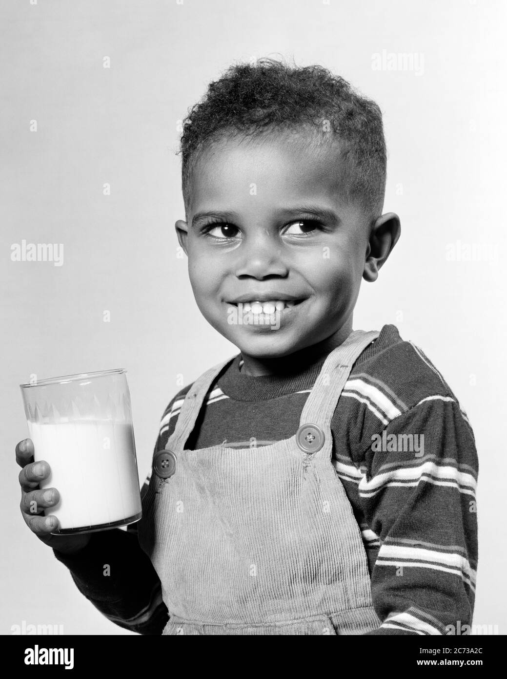 1940 ANNI 1950 SORRIDENTE AFROAMERICANO RAGAZZO TENENDO BERE BICCHIERE DI LATTE INDOSSANDO BIB GLOBALE T-SHIRT A RIGHE GUARDANDO DA PARTE - N628 HAR001 SODDISFAZIONE HARS STRIPED STUDIO SHOT SALUTE CASA VITA CASEARIA COPIA SPAZIO MEZZA LUNGHEZZA MASCHI CONFIDENZA ESPRESSIONI B&W FELICITÀ BEVANDA ALLEGRA AFROAMERICANI AFROAMERICANI ED ECCITAZIONE FLUIDO NERO ETNIA DI A. SMILES CONNESSIONE CONSUMARE IDRATAZIONE GIOIOSA GENERALE T-SHIRT BIB CRESCITA GIOVANILE PROTEINE RINFRESCANTI BEVANDE NERO E BIANCO HAR001 VECCHIO STILE AFRO-AMERICANI Foto Stock