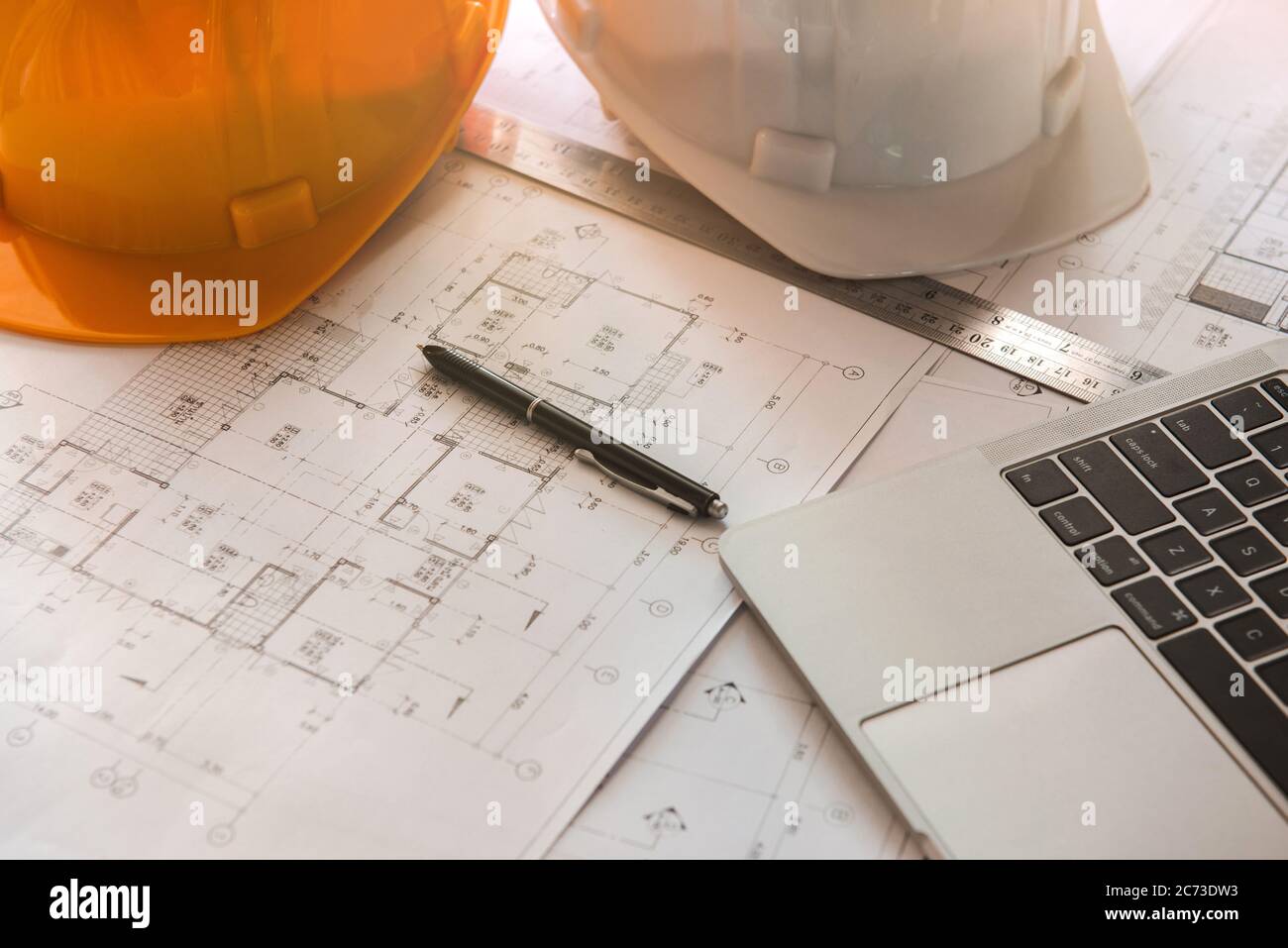 Primo piano di progetti con schizzi di progetti, laptop, casco e alcuni strumenti meccanici. Foto Stock