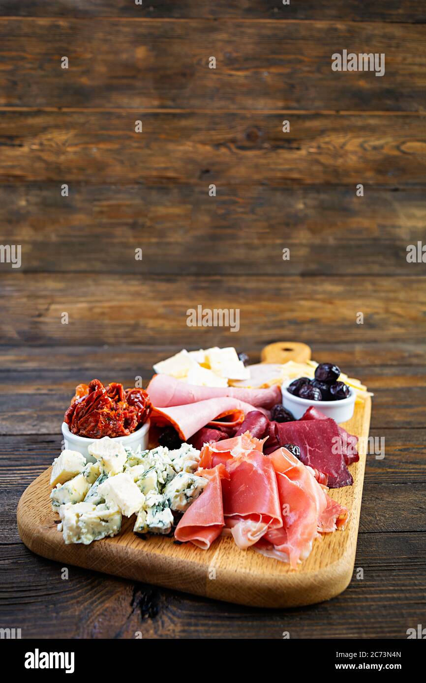 Antipasto italiano. Antipasti con prosciutto, salsami, prosciutto,  parmigiano, formaggio blu e olive Foto stock - Alamy