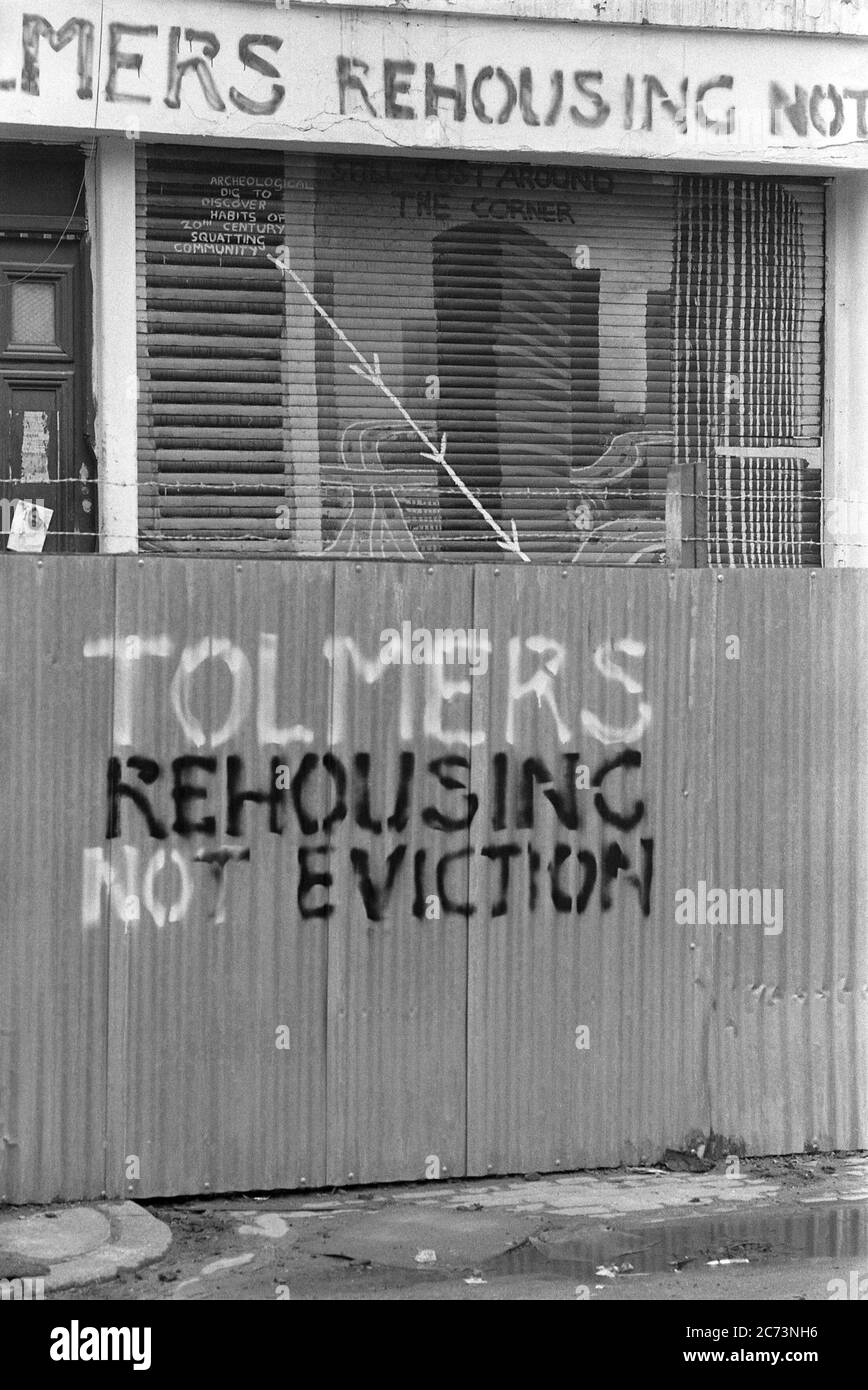 Slogan dipinti a mano su recinzioni in ferro ondulato a Tolmers Square, Somers Town, Londra, Inghilterra, Regno Unito, durante le proteste alla fine degli anni '70. Situato a Somers Town, vicino alla stazione di Euston nel centro di Londra, Tolmers Square fu occupata da più di cento quadranti negli anni '70, che, insieme ai gruppi locali, lottarono per un piano di riqualificazione che adattò la comunità locale. Nel 1975, il "Tolmers Village" aveva 49 squadre che ospitavano oltre 180 persone. I quadranti vi vivevano per sei anni. Molte delle proposte dei manifestanti hanno portato alla costruzione di abitazioni invece che di uffici a Piazza Tolmers. Foto Stock