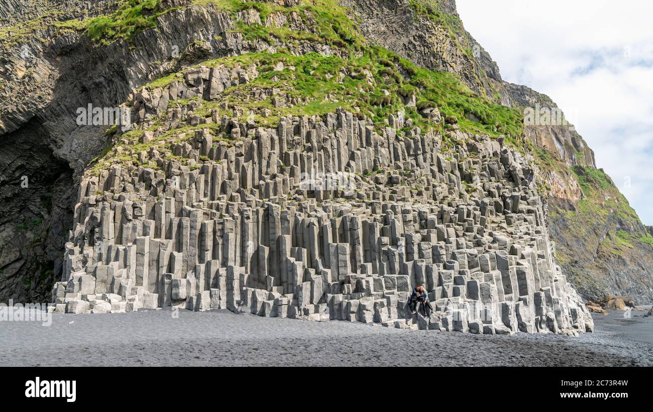 Reynisfjara, Islanda - Agosto 2019: La spiaggia di sabbia nera di Reynisfjara, il monte Reynisfjall e le colonne di basalto vulcanico nella costa meridionale dell'IC Foto Stock