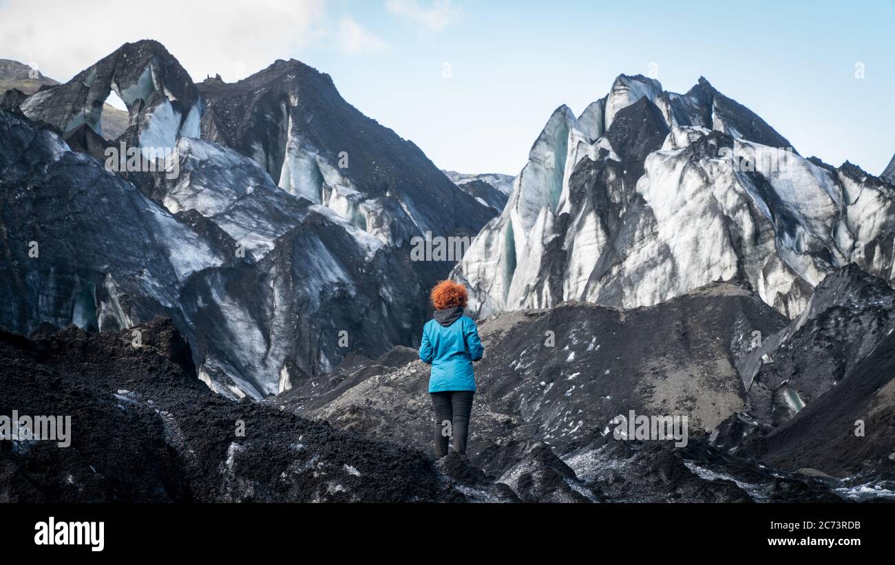 Solheimajokull, Islanda - Maggio 2019: Donna non identificata in piedi presso il ghiacciaio di uscita Solheimajokull in Islanda Foto Stock