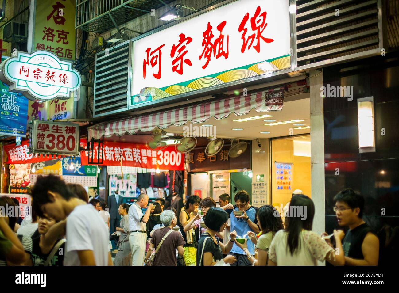 Ay-Chung Flour-Rice Noodle a Taipei. Ancora affollata di notte con tutti i partecipanti che tengono una ciotola fuori dal negozio per mangiare. Foto Stock