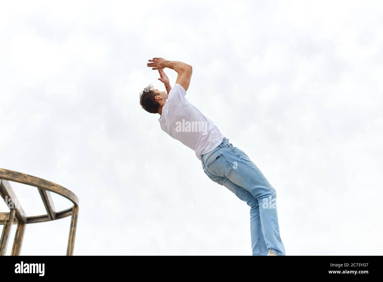 giovane uomo ambizioso praticare esercizi di parkour per strada. vista laterale foto. stile di vita attivo Foto Stock