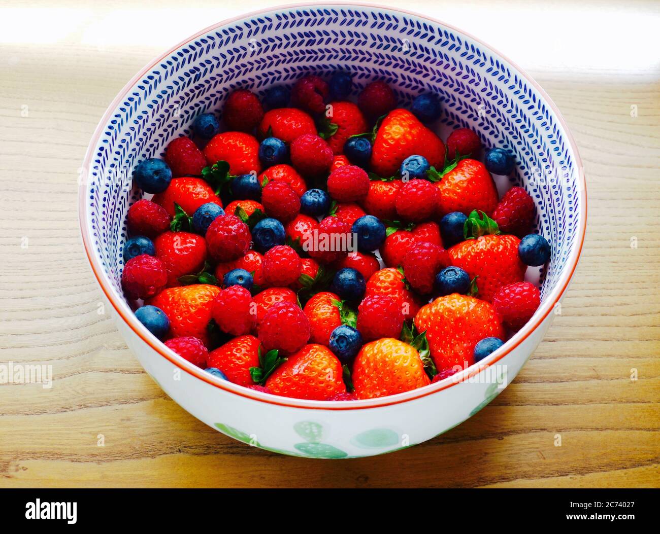 Fragole, lamponi e mirtilli in una ciotola Foto Stock