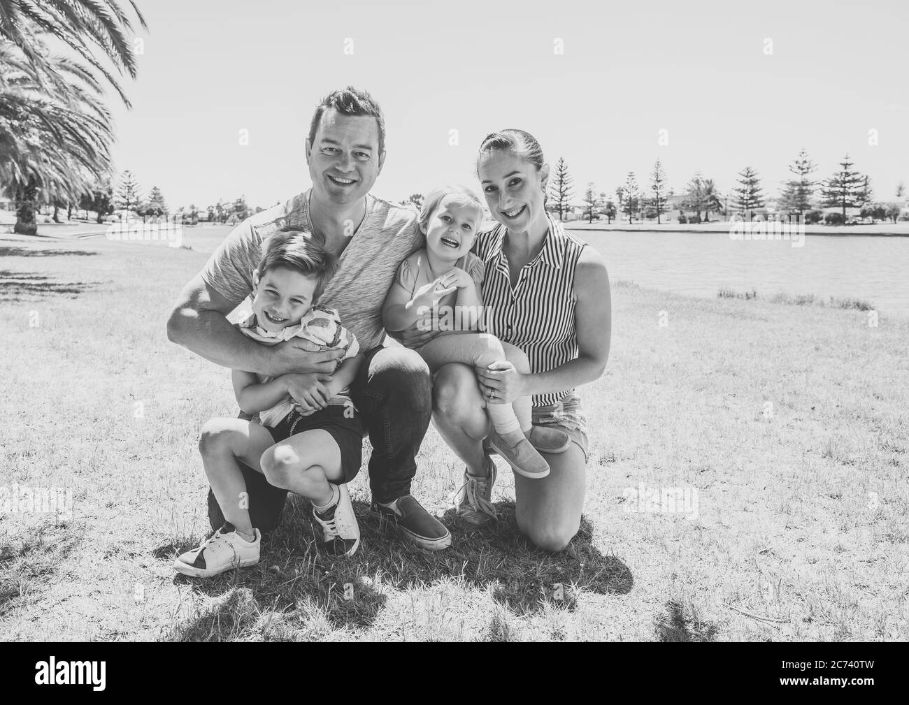 Felice ritratto di famiglia di madre, padre, figlio e figlia che si divertono insieme nel parco. Ragazzo e bambina che si divertono con i loro genitori. Posiz Foto Stock